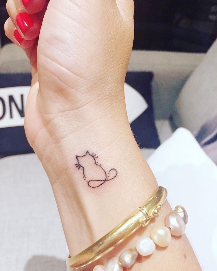 Tatuaje de mujer en la muñeca gato silueta